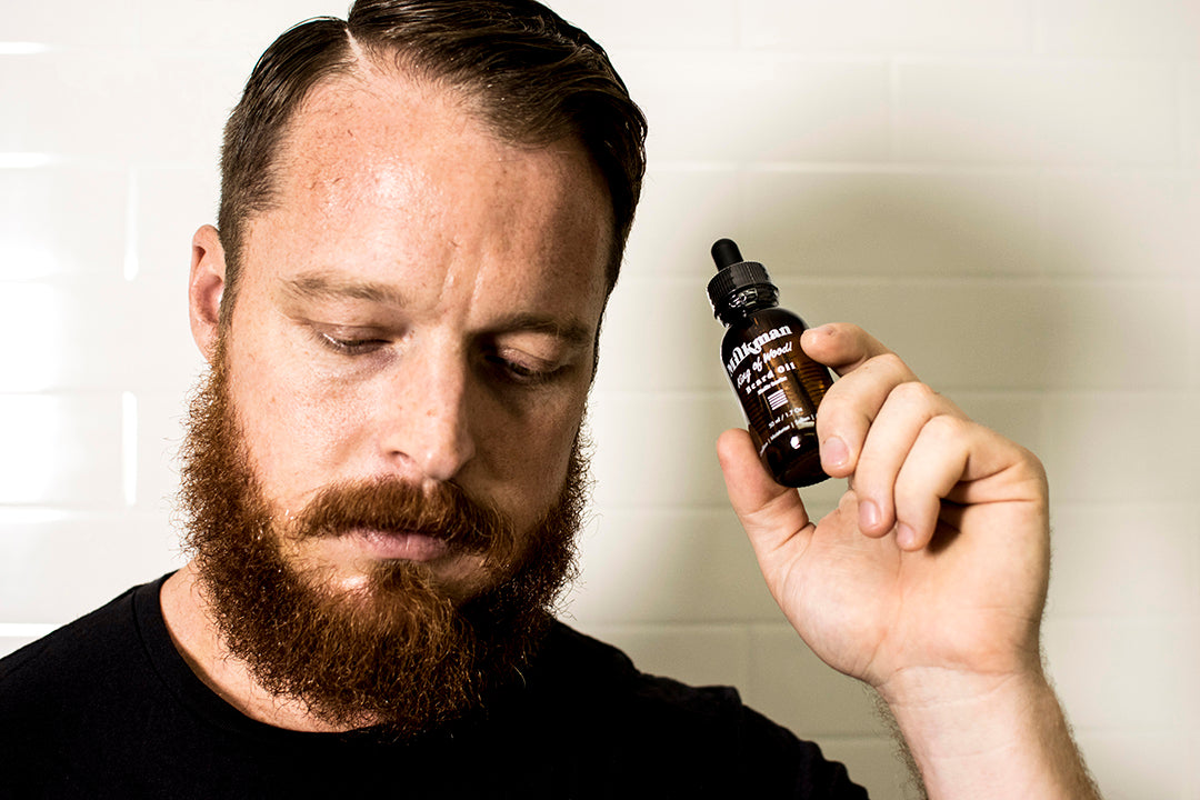 bearded man holding Milkman beard oil