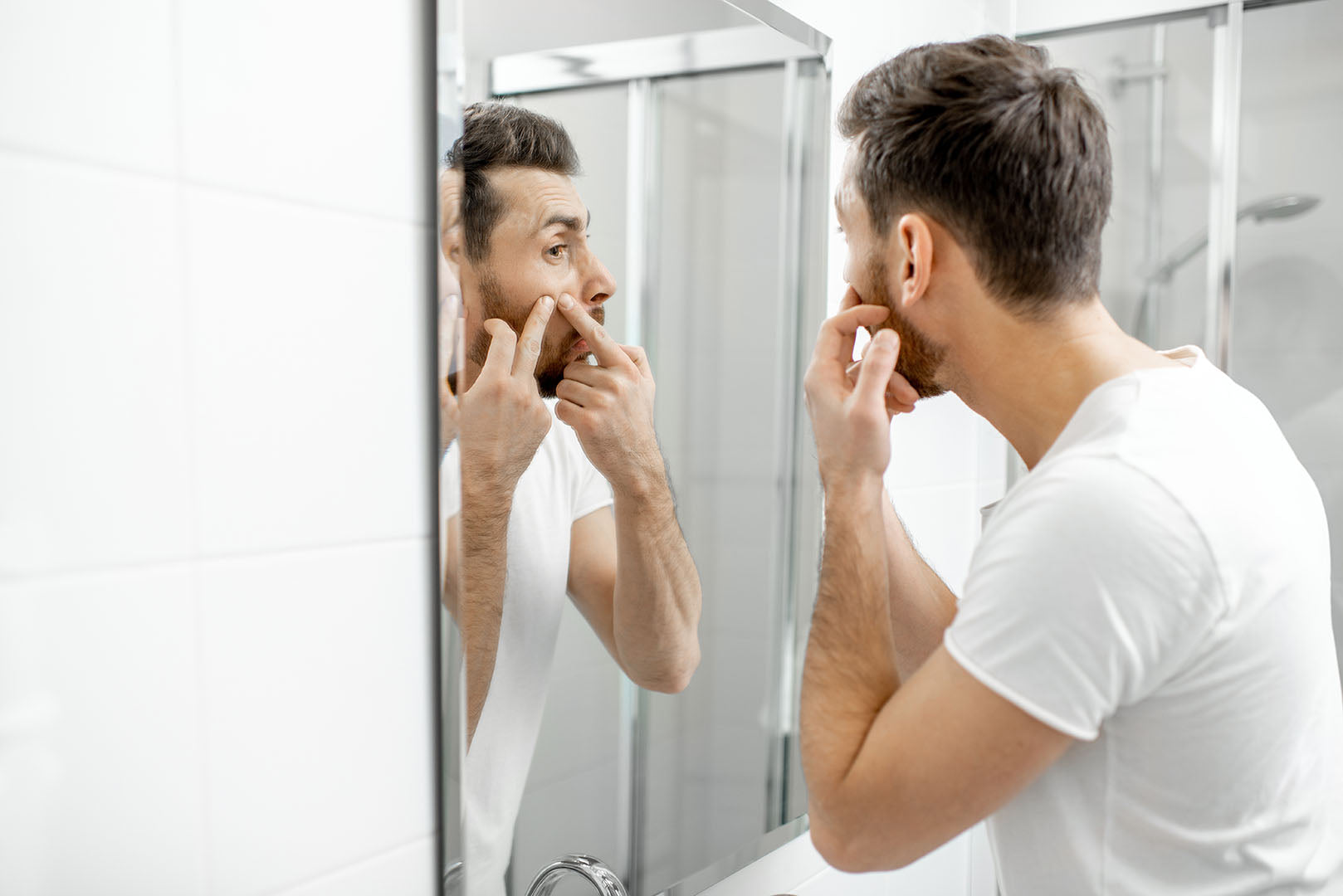 beard acne man squeezing beard pimple