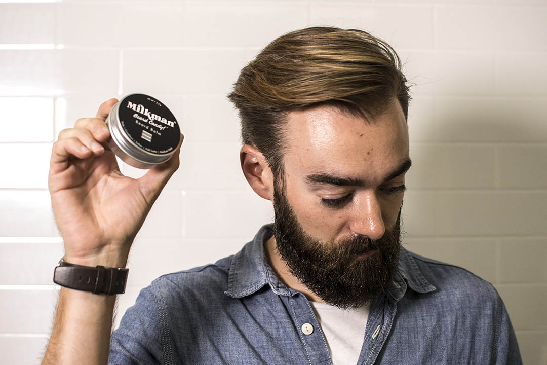 bearded man holding milkman beard balm