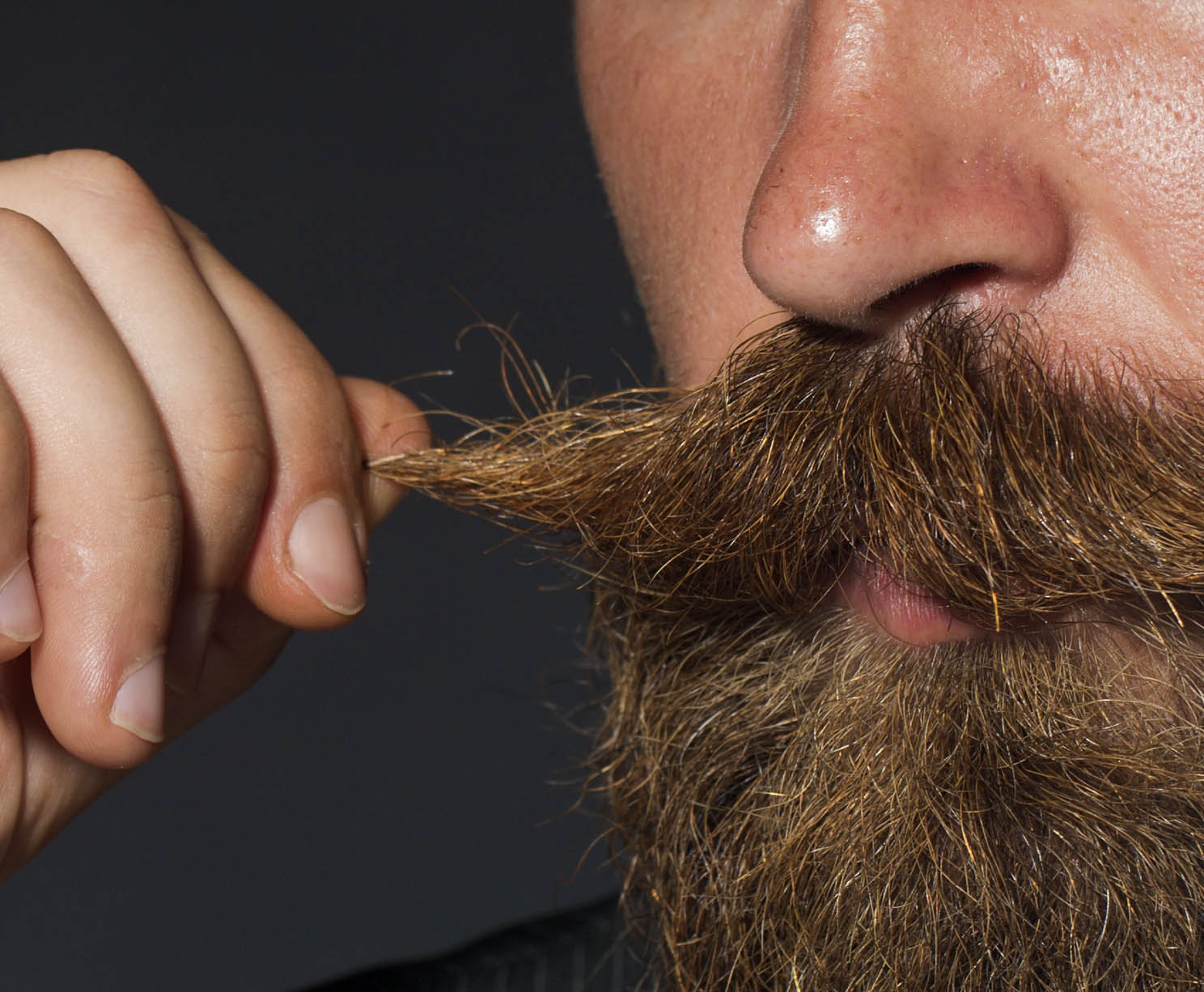 man twirling thick moustache
