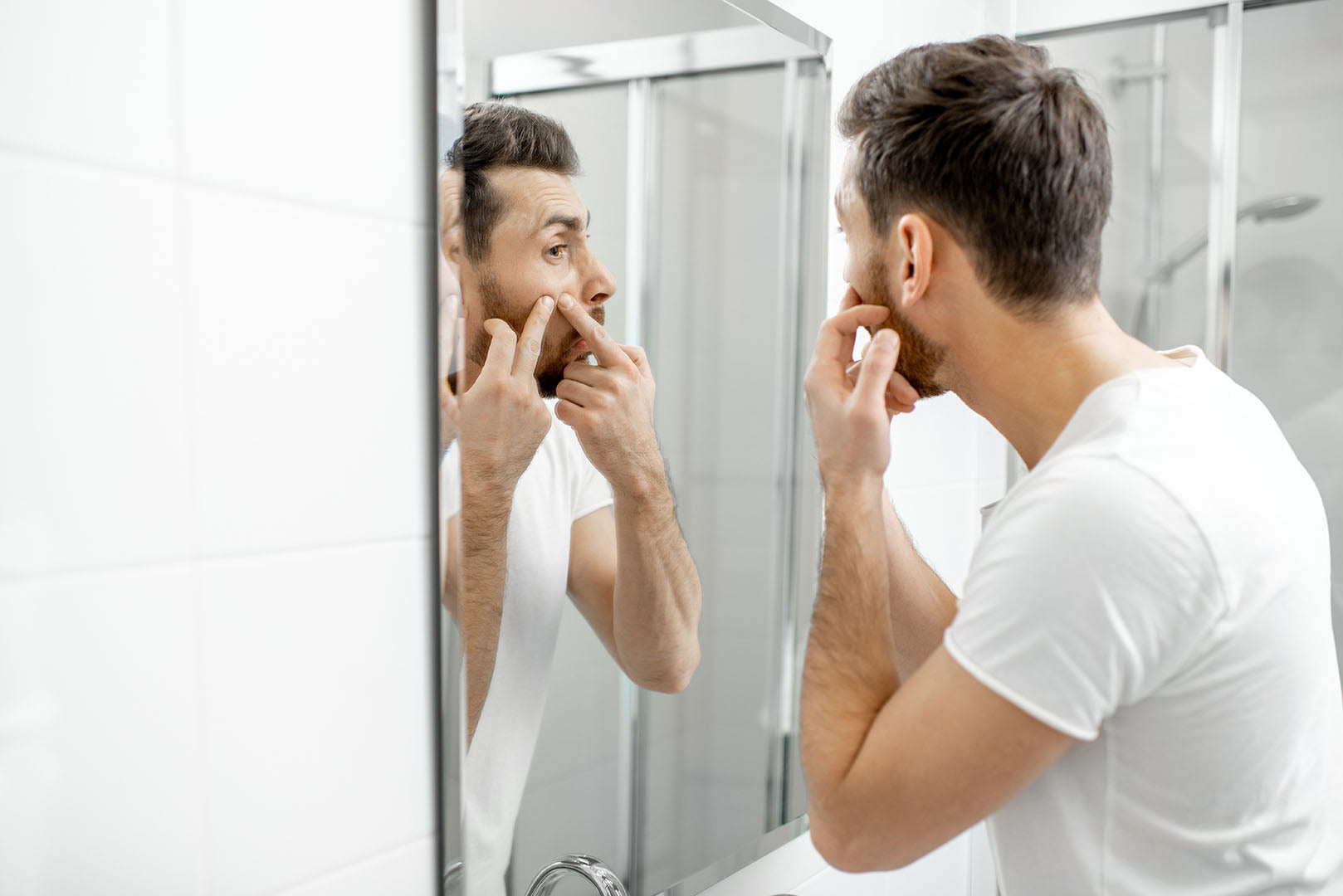 beard acne man squeezing beard pimple