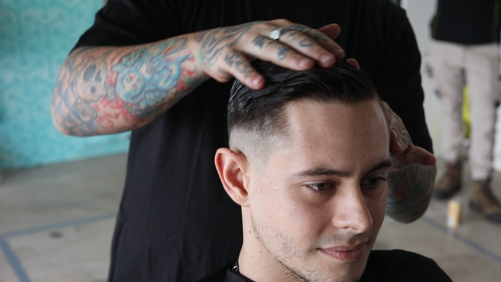 barber cradling a man's hair after a barber shop hair cut whilst talking about hair care myths