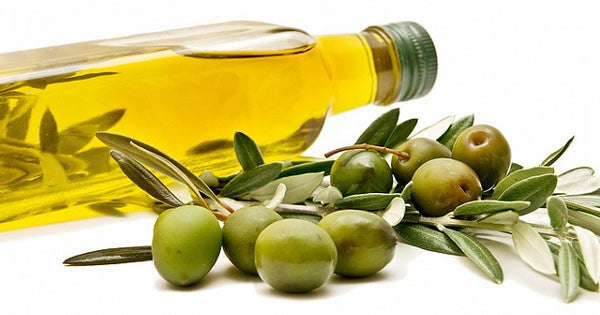bottle of olive oil next to olives