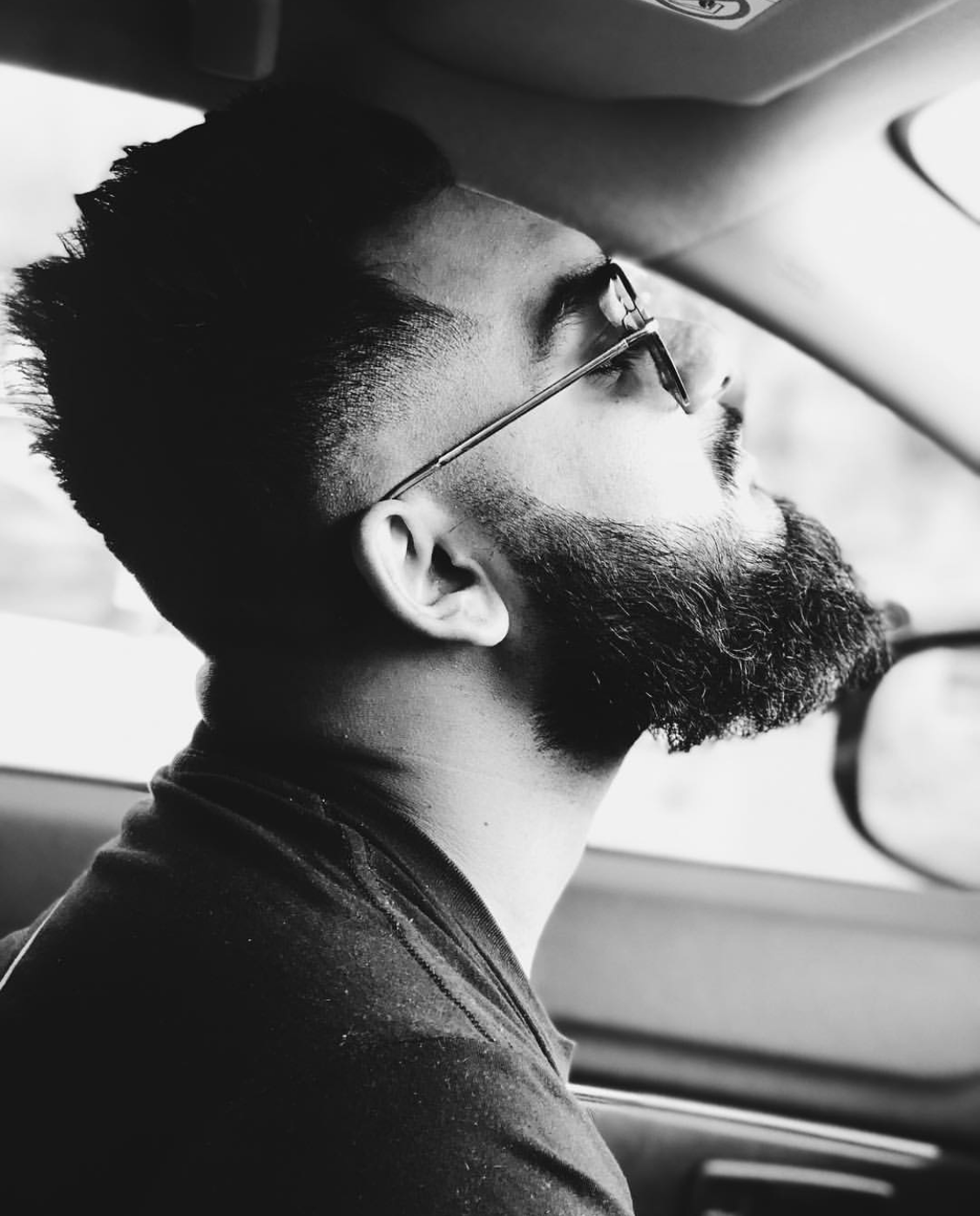 man checking his beard sculpting in the mirror