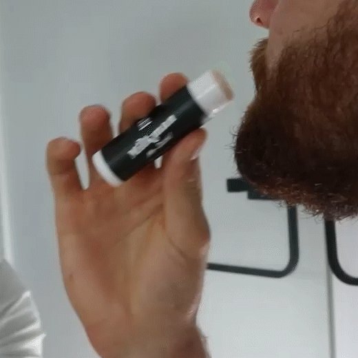 man applying milkman moustache wax to his moustache