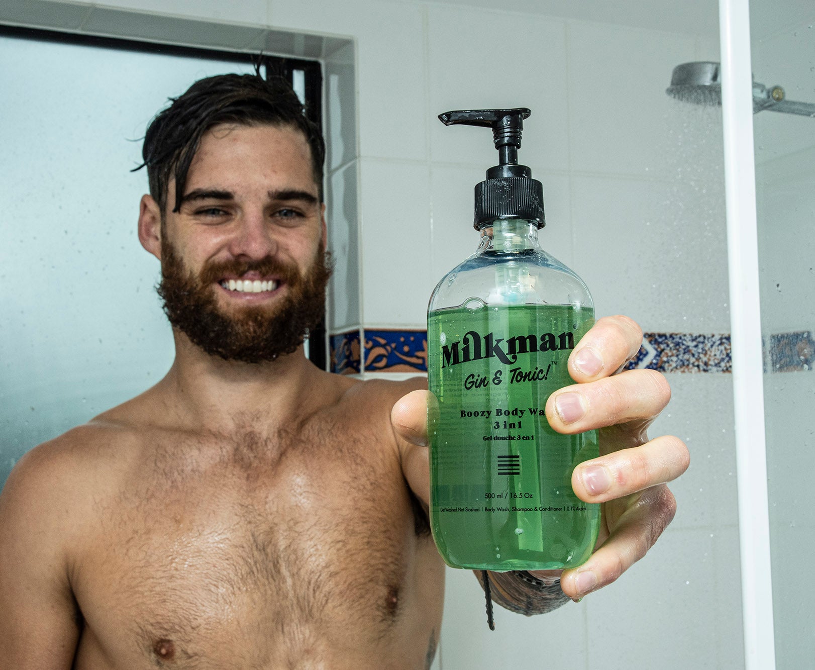 man holding milkman men's body wash with Gin and Tonic scent