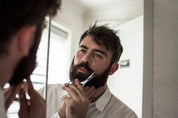 moustache scissor being used by a bearded man