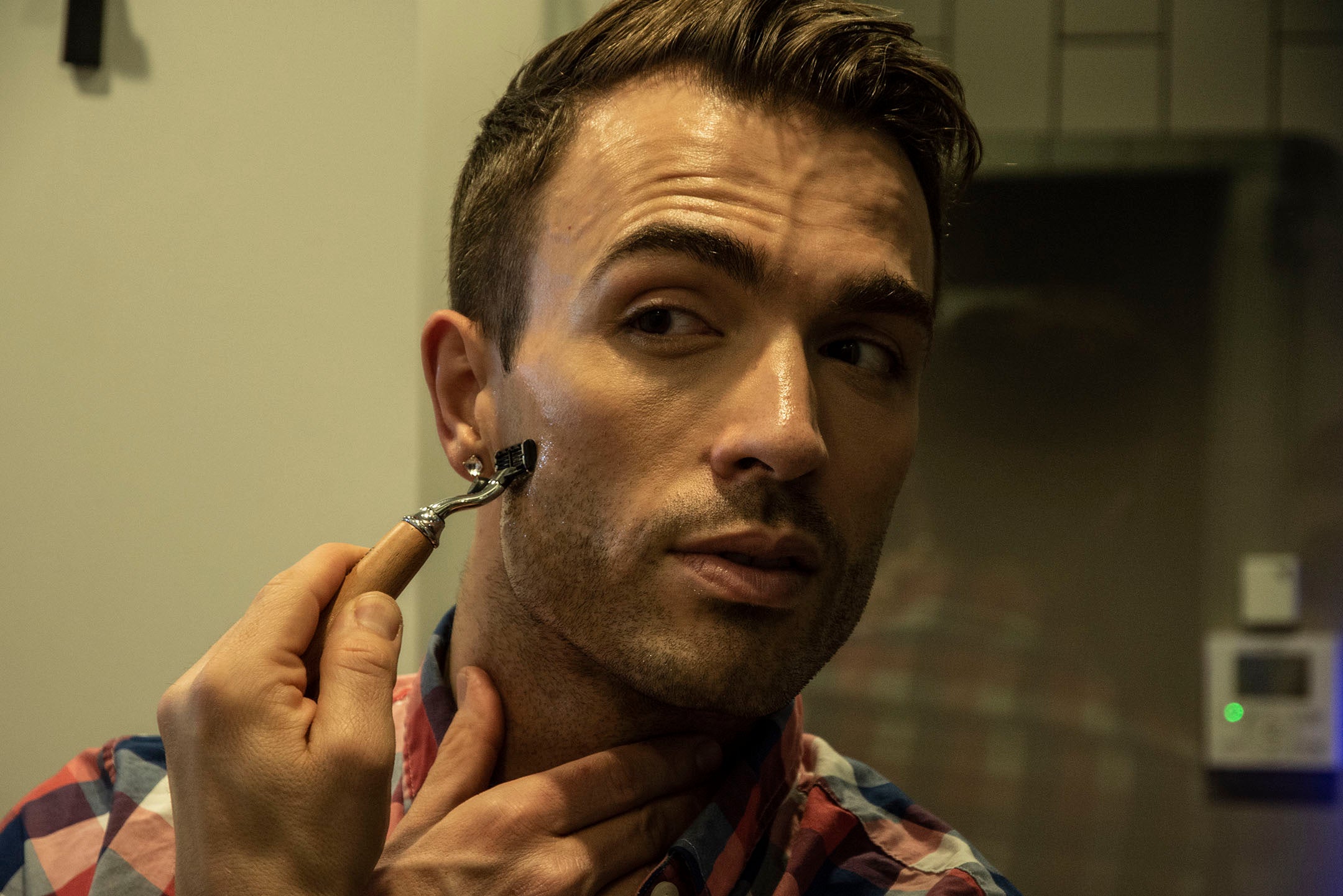 man using milkman shave oil and a mach 3 razor to shave his stubble