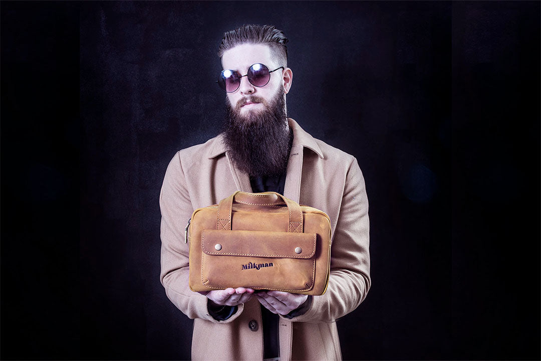 bearded man holding milkman leather dopp bag